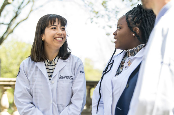 Three osteopathic medical students talking outside.