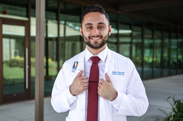 DO student poses in white coat