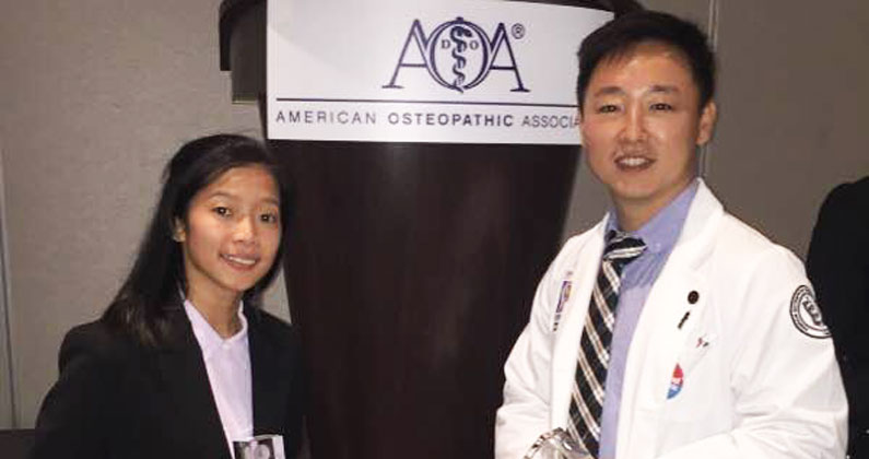 PCOM Georgia students smile in their white coats at the research event.