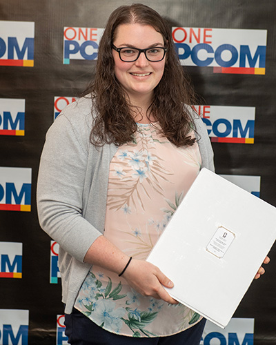 PCOM Georgia anatomical coordinator Hannah Zepplin, CFSP, LFD, LE, holds her DEI award and smiles